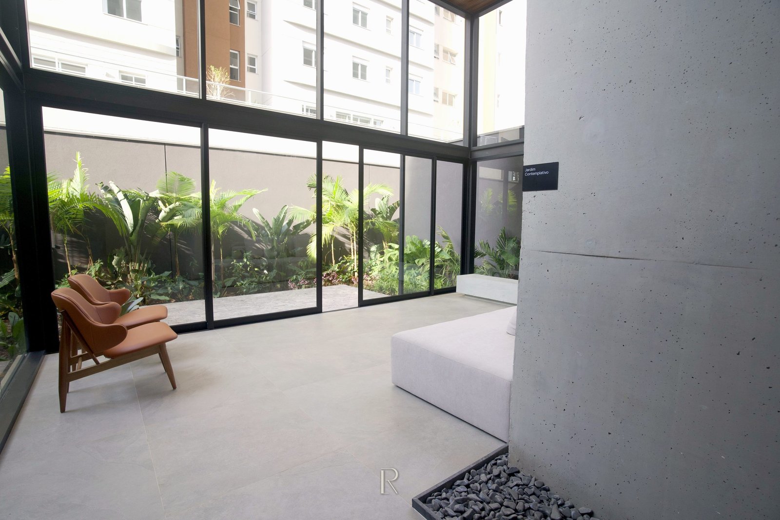 Hall envidraçado do Matiss, com pilar de concreto aparente e jardim interno